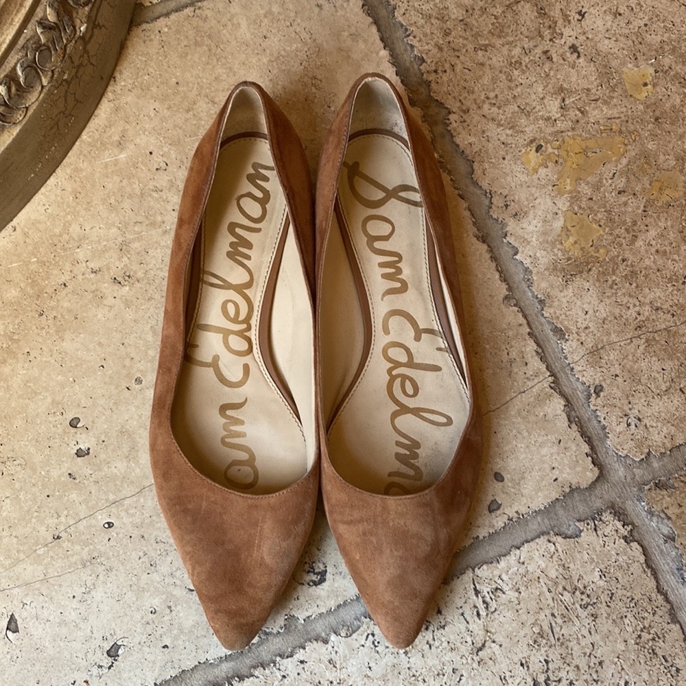 Tan suede flats with gold embellishments at heel